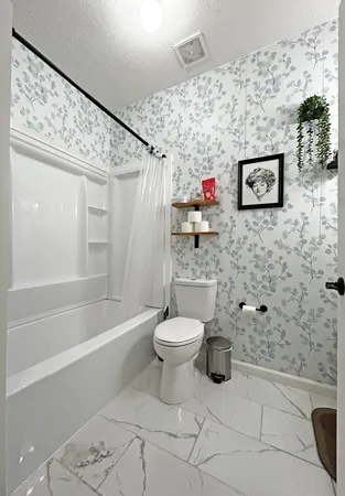 a bathroom with a toilet and a shower