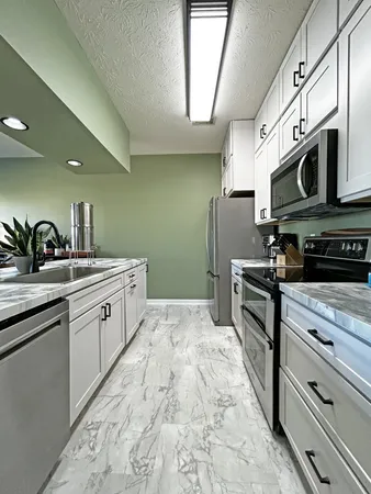 a kitchen with stainless steel appliances granite countertop a sink a stove and microwave