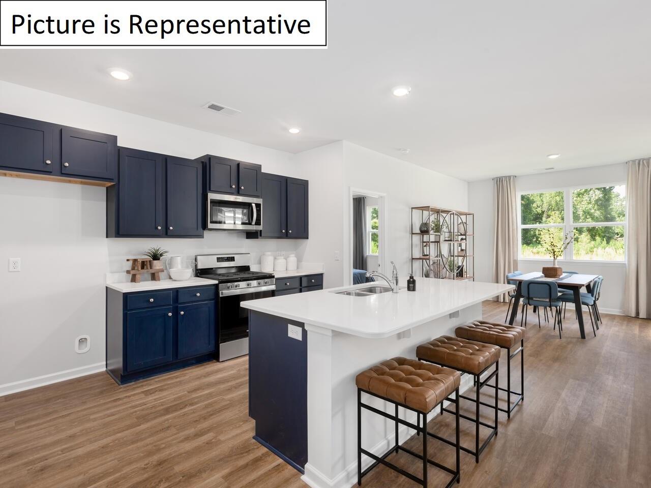 1120 Secrest Cmns Drive Monroe, NC 28112 - Photo 9 of 25 a kitchen with stainless steel appliances granite countertop a stove top oven a sink dishwasher a dining table and chairs with wooden floor