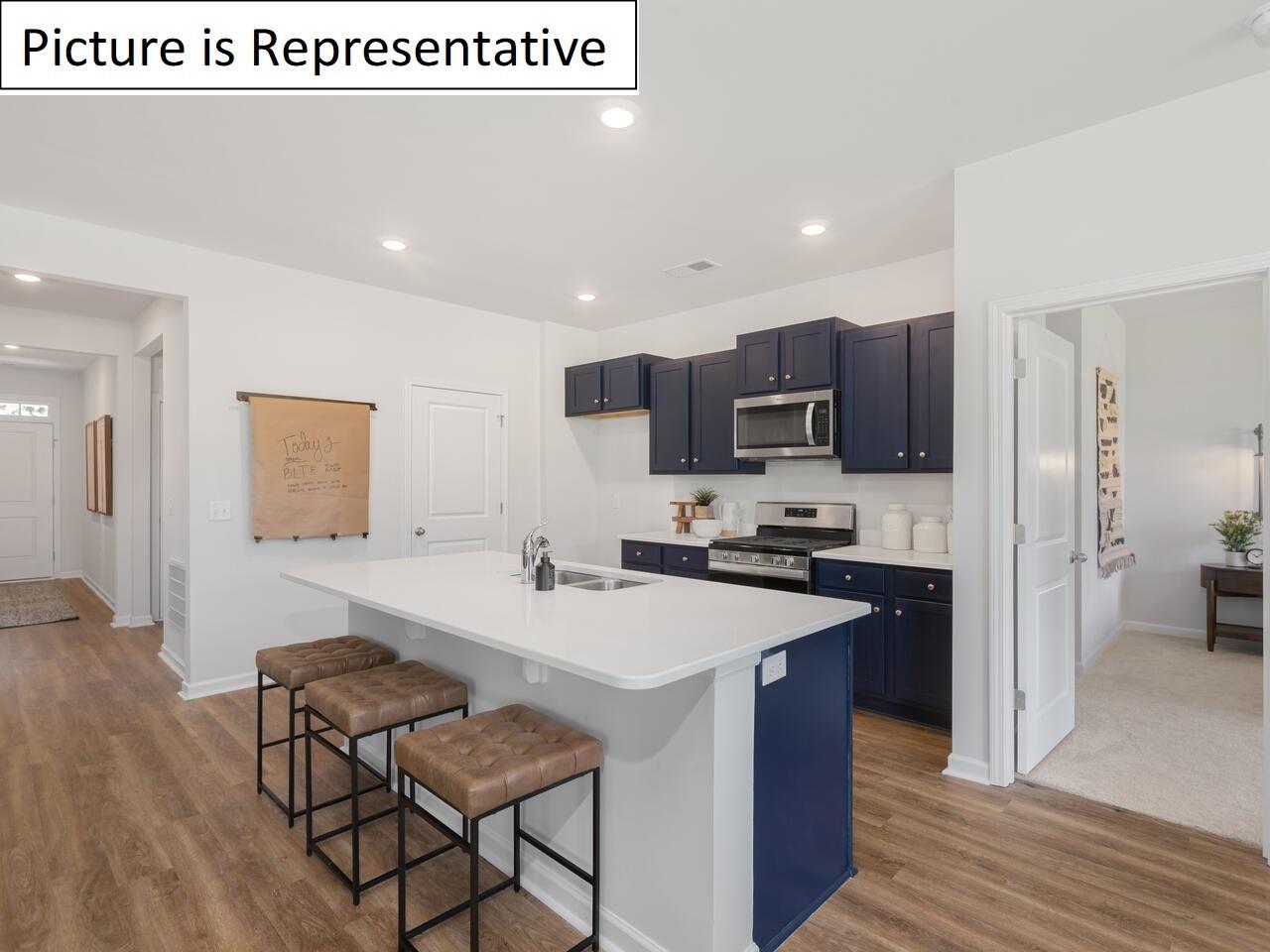1120 Secrest Cmns Drive Monroe, NC 28112 - Photo 10 of 25 a kitchen with a sink a microwave a refrigerator and chairs