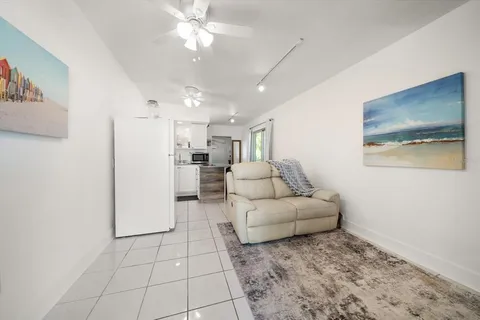 a living room with furniture and a view of kitchen