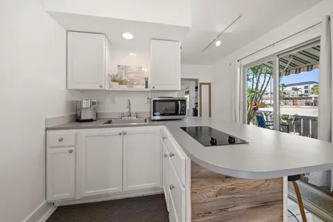 a kitchen with stainless steel appliances granite countertop a stove a sink a refrigerator and a granite counter tops with white cabinets