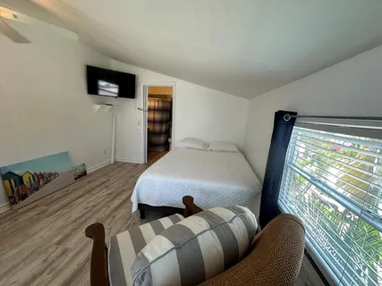 a bedroom with furniture and a flat screen tv