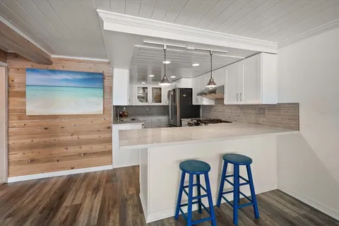 a kitchen with a table chairs refrigerator and microwave