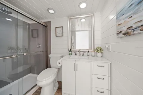 a bathroom with a granite countertop sink toilet and shower