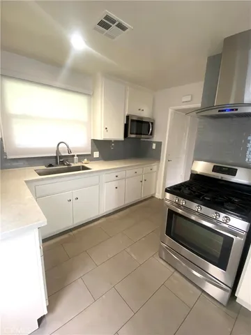 a kitchen with stainless steel appliances a sink stove and cabinets