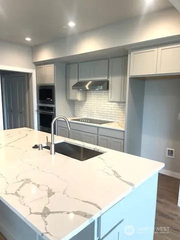 a kitchen with kitchen island a sink stainless steel appliances and cabinets