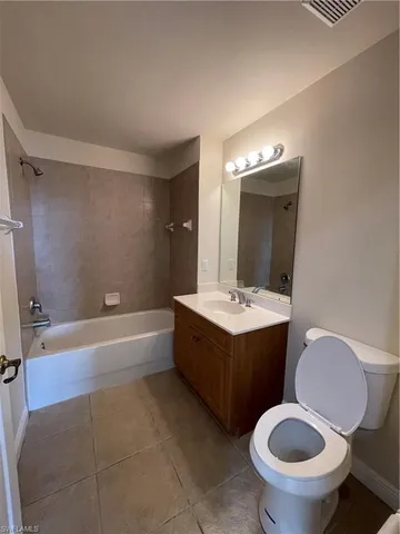 a bathroom with a granite countertop toilet sink and mirror