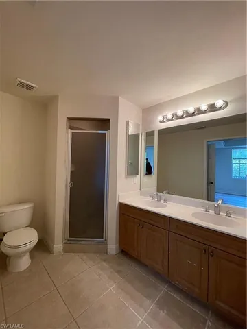 a spacious bathroom with a granite countertop sink toilet and mirror