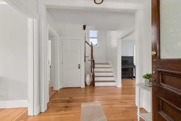 a view of entryway and hall with wooden floor