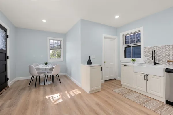 a view of a kitchen with a dining table chairs and wooden floor