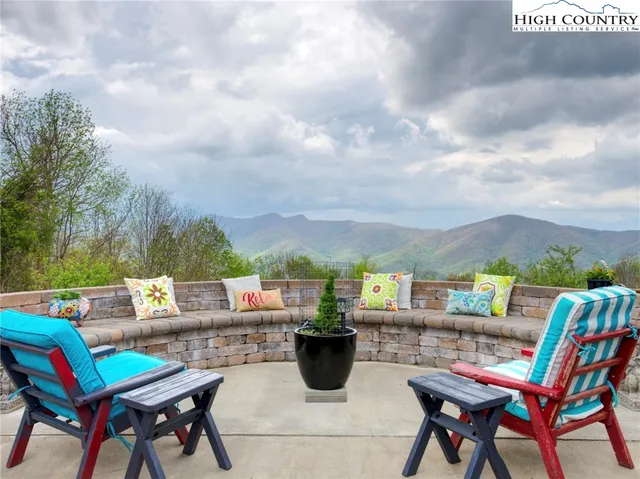 a balcony with chairs and a potted plant