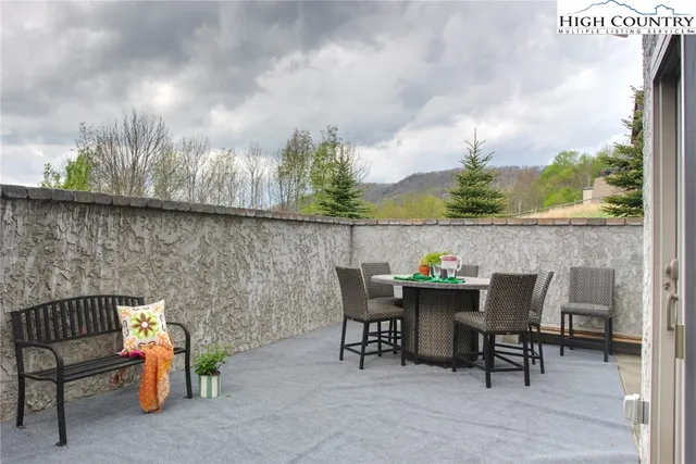 a roof deck with a potted plant and outdoor seating