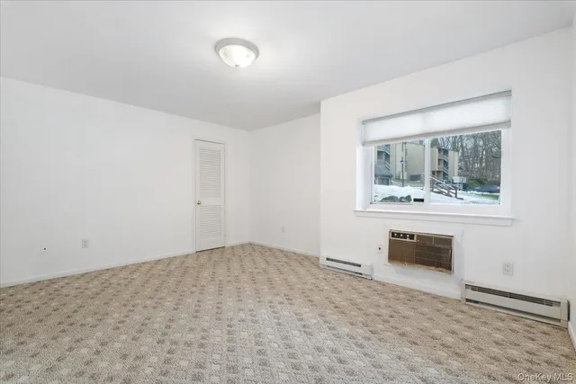 an empty room with windows and mirror