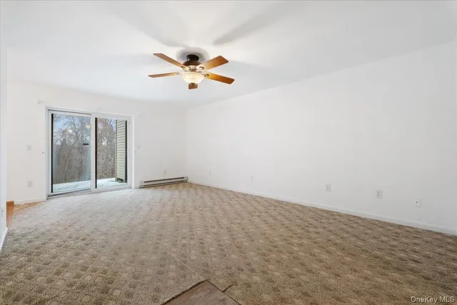 an empty room with a window and ceiling fan