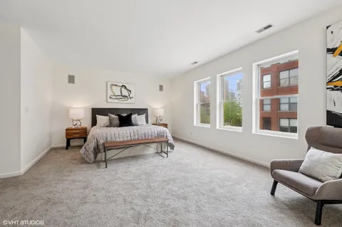 a bedroom with a bed and a couch with window