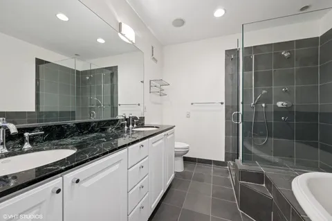 a bathroom with a double vanity sink toilet and shower