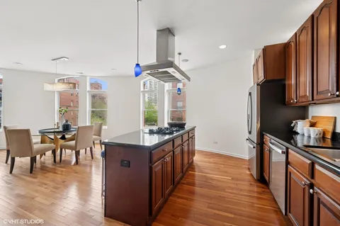 a kitchen with stainless steel appliances granite countertop a stove and a wooden floors