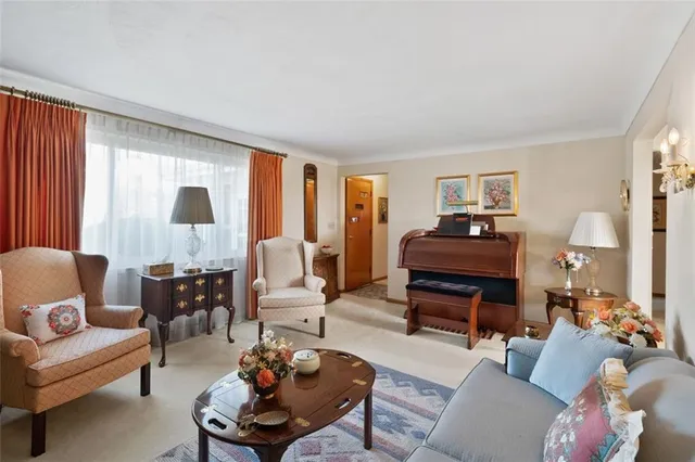 a living room with furniture a large window and a flat screen tv