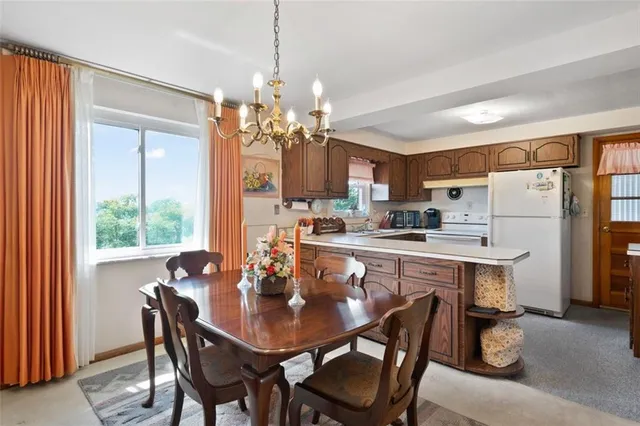 a dining room filled a chandelier a table and chairs