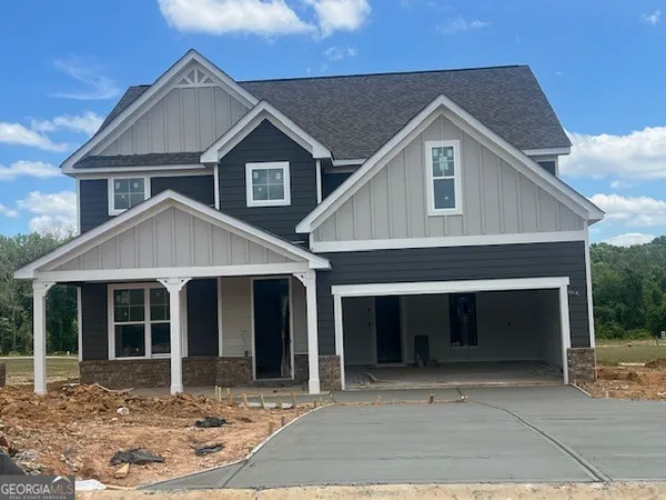 a front view of a house with yard and parking space