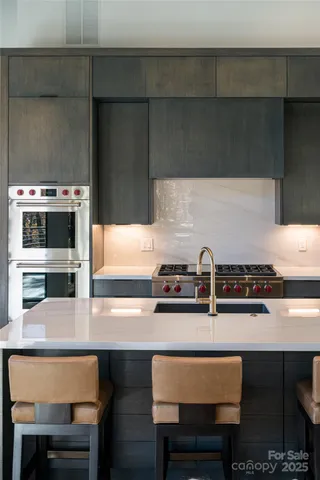 a room with stainless steel appliances kitchen island granite countertop furniture and a large window