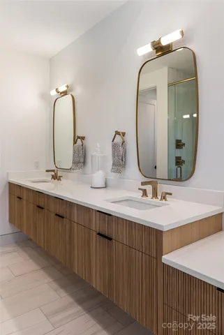 a spacious bathroom with a double vanity sink a mirror and bathtub