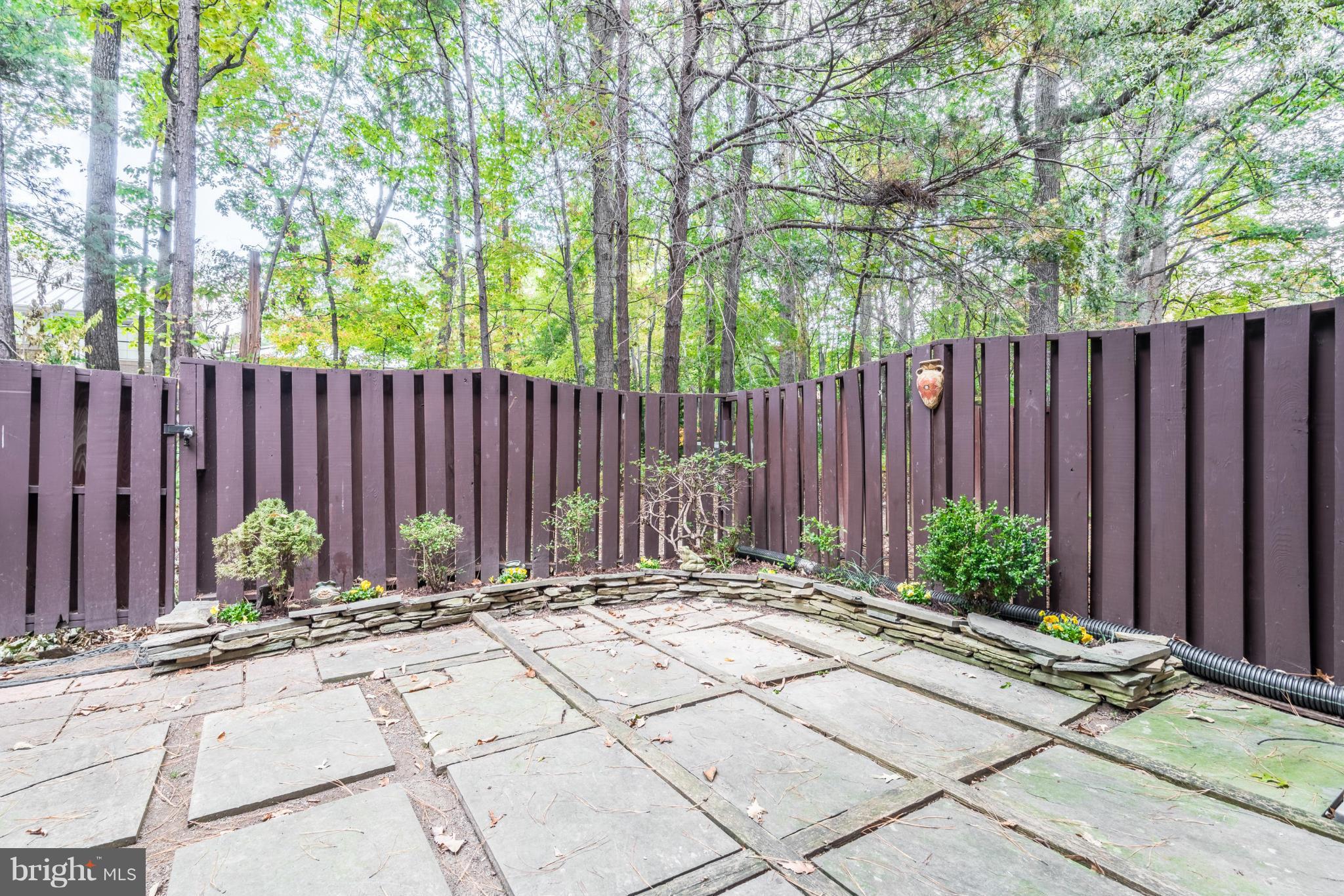 2402 Southgate Square Reston, VA 20191 - Photo 19 of 21 a view of a backyard with a large tree and wooden fence