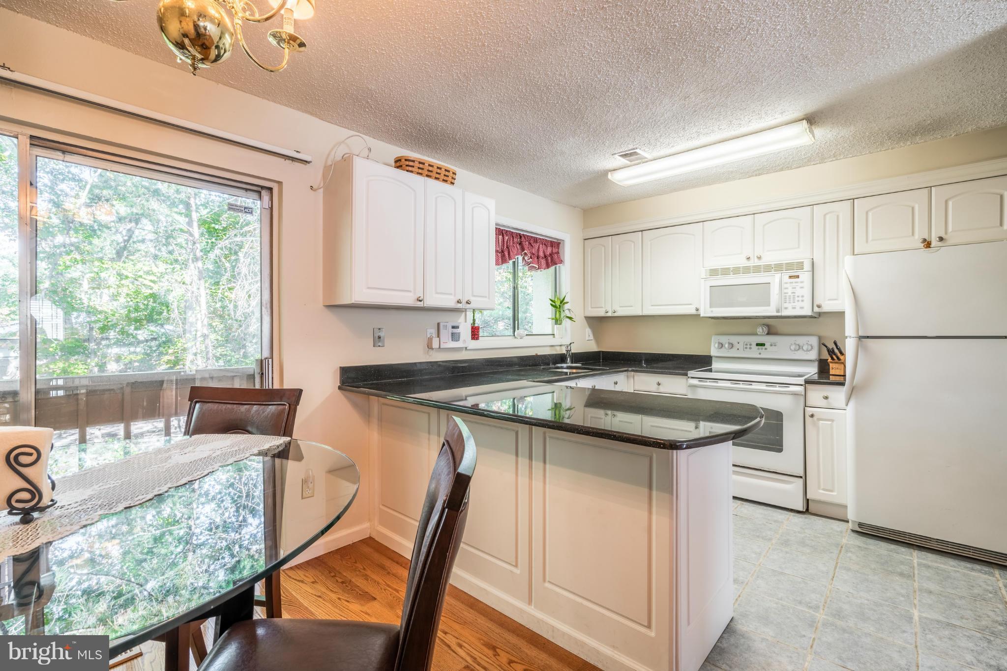2402 Southgate Square Reston, VA 20191 - Photo 9 of 21 a kitchen with stainless steel appliances granite countertop a stove refrigerator sink and white cabinets