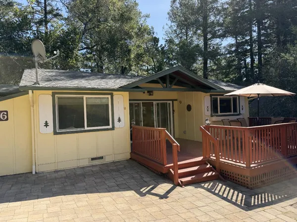 a view of house with a deck and furniture