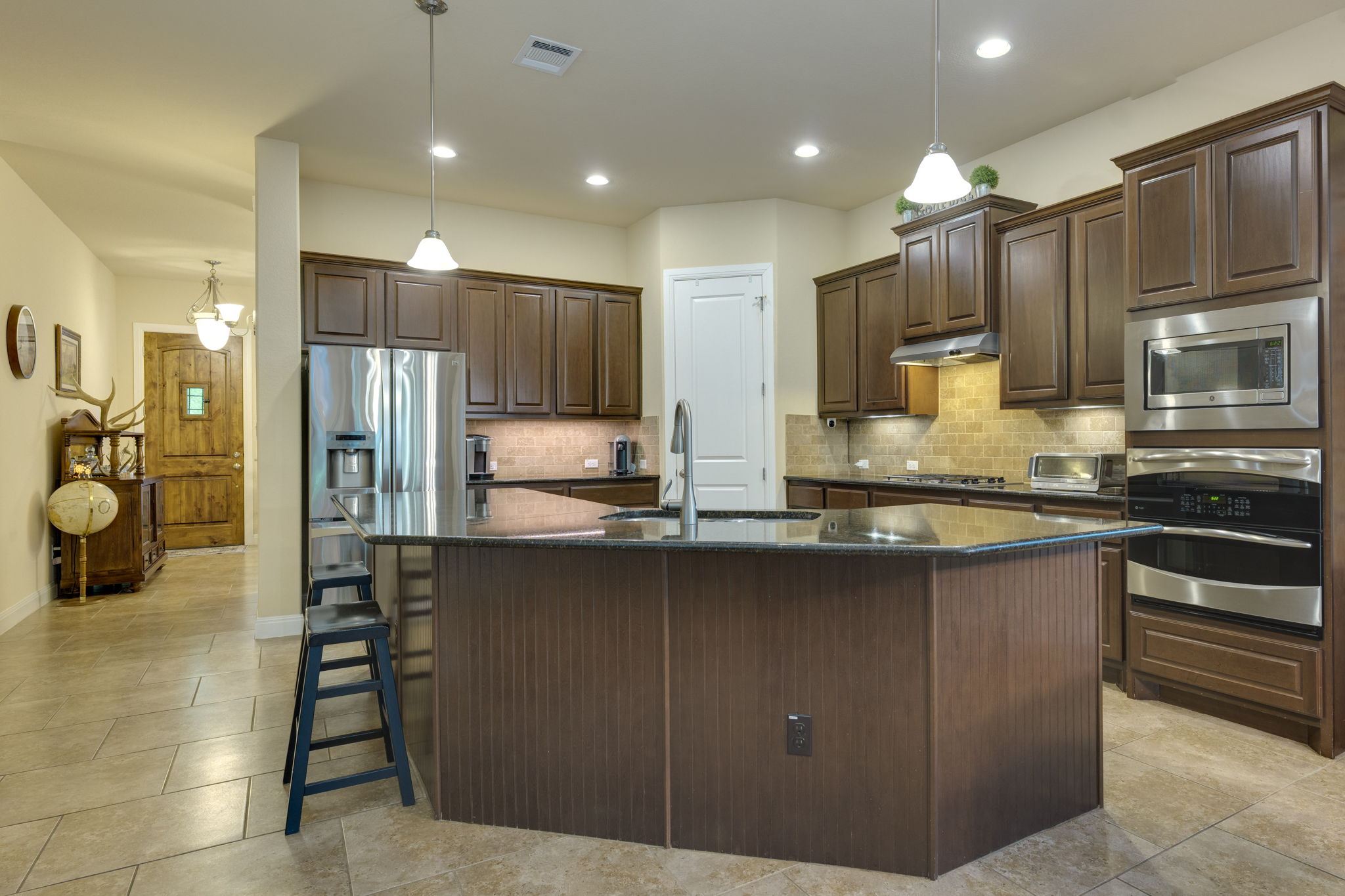 2208 Allison Way Cedar Park, TX 78613 - Photo 7 of 40 a kitchen with stainless steel appliances kitchen island granite countertop a refrigerator and cabinets