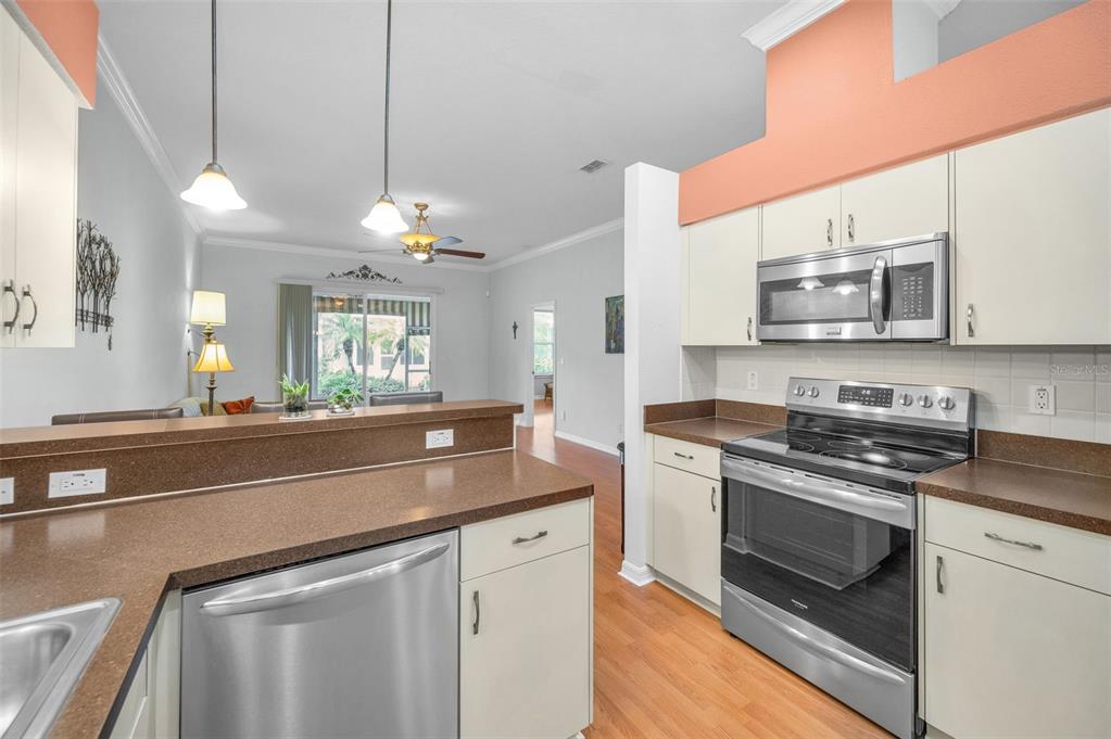 12154 Putter Green Court New Port Richey, FL 34654 - Photo 11 of 73 a kitchen with stainless steel appliances granite countertop a stove a sink and a microwave
