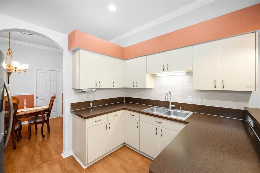 12154 Putter Green Court New Port Richey, FL 34654 - Photo 13 of 73 a kitchen with granite countertop a sink a stove and white cabinets