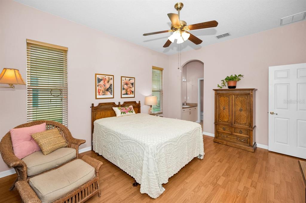 12154 Putter Green Court New Port Richey, FL 34654 - Photo 20 of 73 a bedroom with a bed and a chandelier