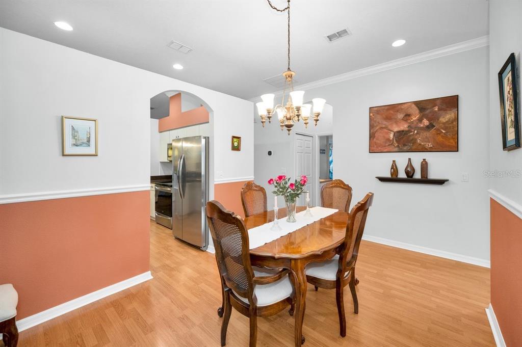 12154 Putter Green Court New Port Richey, FL 34654 - Photo 6 of 73 a dining room with furniture a chandelier and wooden floor