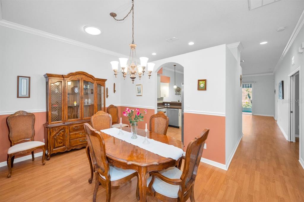 12154 Putter Green Court New Port Richey, FL 34654 - Photo 7 of 73 a view of a dining room with furniture wooden floor and chandelier