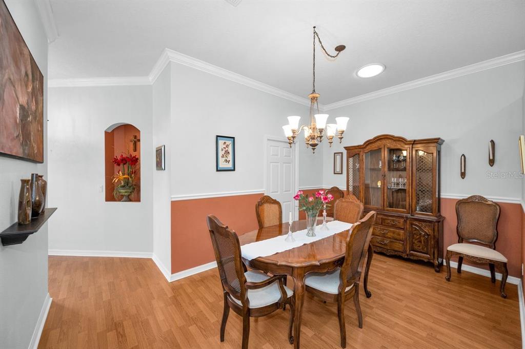 12154 Putter Green Court New Port Richey, FL 34654 - Photo 8 of 73 a view of a dining room with furniture wooden floor and chandelier