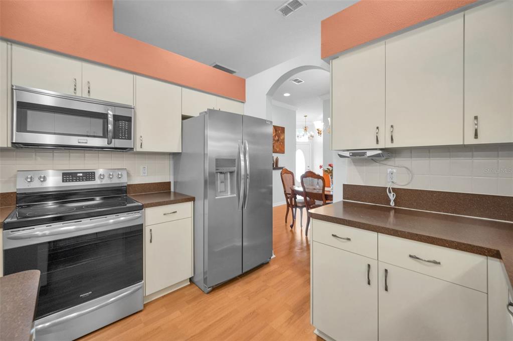 12154 Putter Green Court New Port Richey, FL 34654 - Photo 10 of 73 a kitchen with stainless steel appliances granite countertop a stove a refrigerator and a microwave