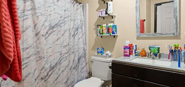 a bathroom with a sink vanity mirror and toilet