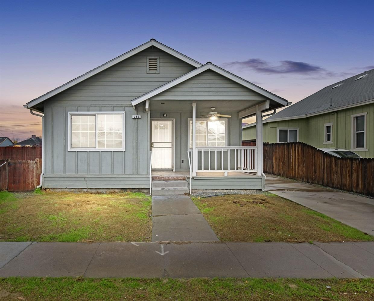 a view of a house with a small yard and wooden fence