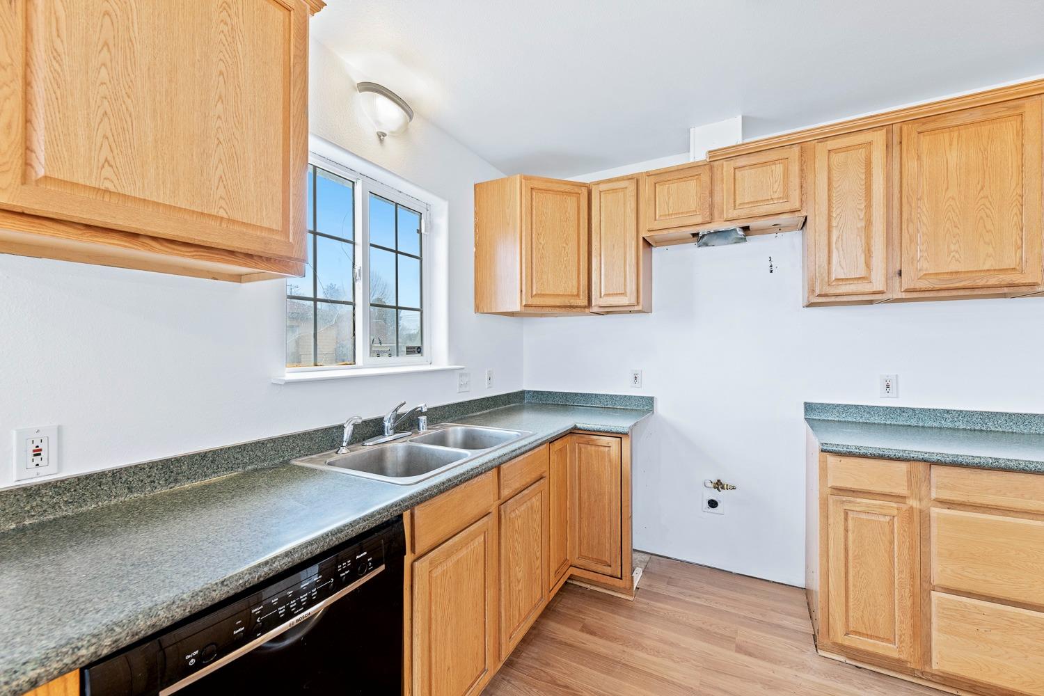 249 Jackson Street Coalinga, CA 93210 - Photo 13 of 42 a kitchen with a sink cabinets and a window