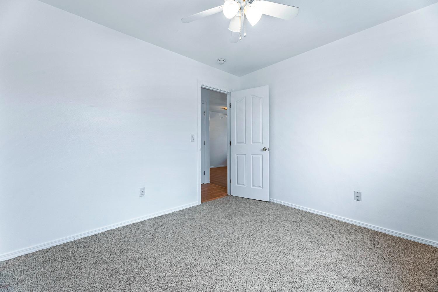249 Jackson Street Coalinga, CA 93210 - Photo 18 of 42 an empty room with a chandelier fan