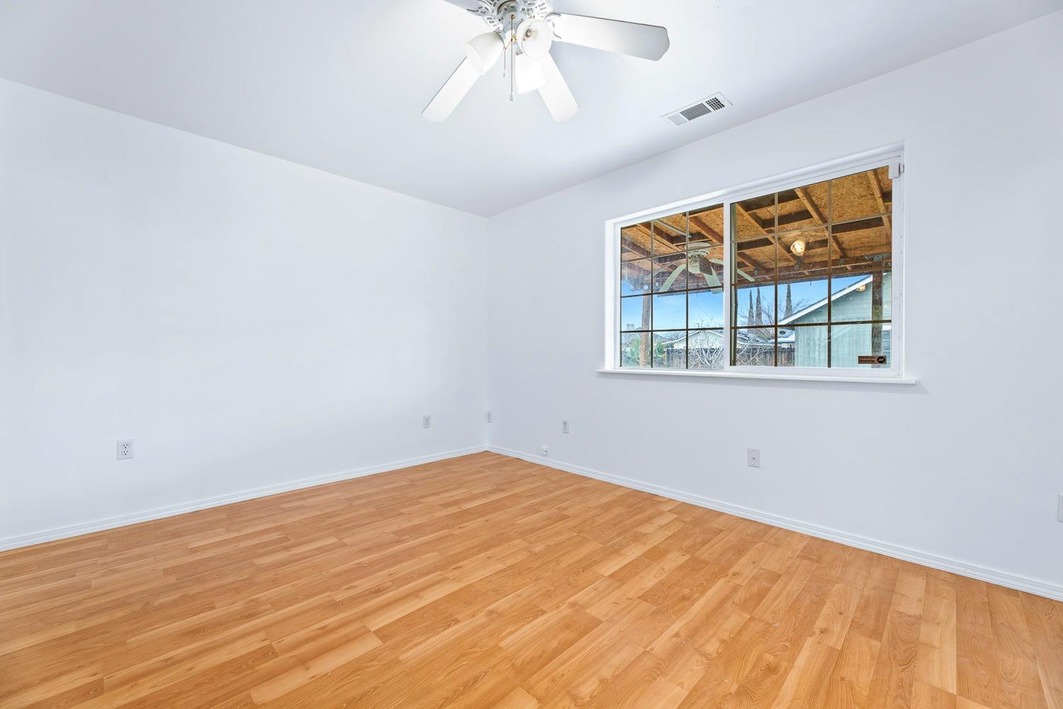 249 Jackson Street Coalinga, CA 93210 - Photo 21 of 42 wooden floor in an empty room with a window
