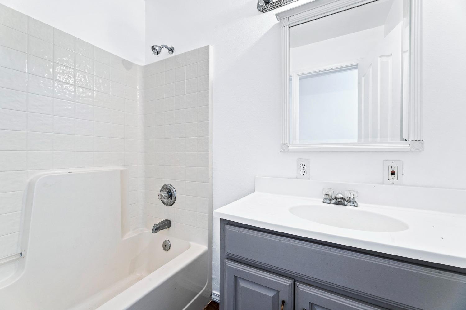 249 Jackson Street Coalinga, CA 93210 - Photo 29 of 42 a bathroom with a sink a bathtub and a mirror