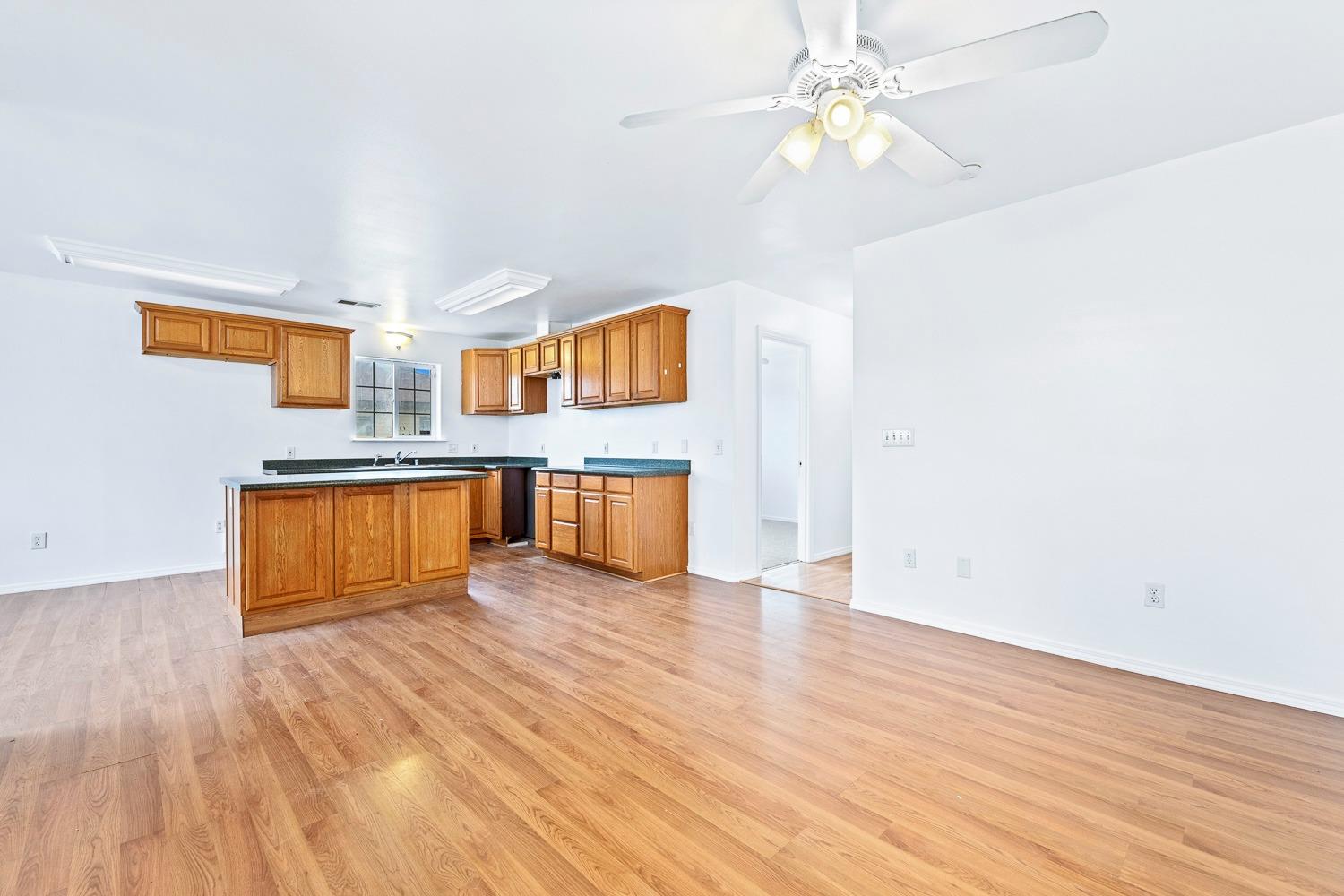 249 Jackson Street Coalinga, CA 93210 - Photo 7 of 42 a view of kitchen with wooden floor electronic appliances and window