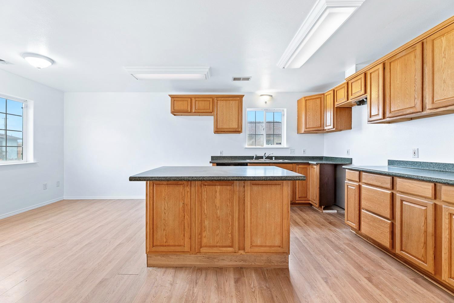 249 Jackson Street Coalinga, CA 93210 - Photo 10 of 42 a kitchen with stainless steel appliances granite countertop a sink a stove a refrigerator cabinets and wooden floor