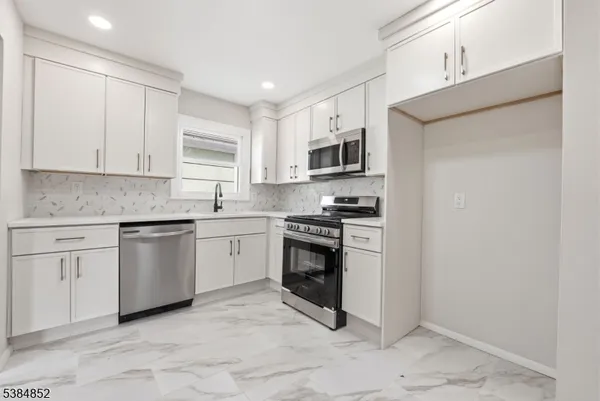 a kitchen with cabinets stainless steel appliances and a window