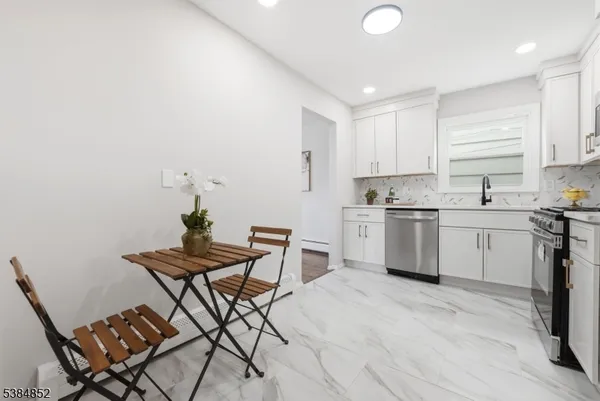 a kitchen with a sink a window and chairs