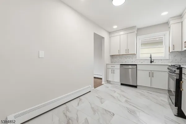 a kitchen with granite countertop white cabinets and white appliances