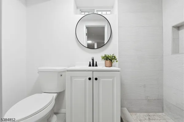 a bathroom with a toilet a sink and mirror